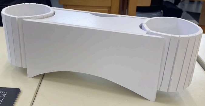 A curved foam board organizer with two cylindrical pen wells