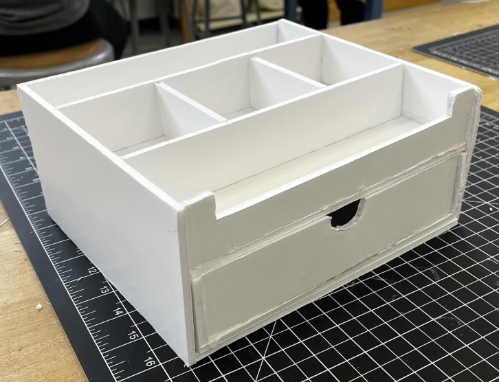 A finished foam board desktop organizer with a tray and pen tower